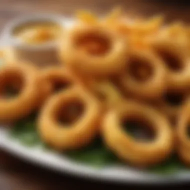 A platter of golden onion rings with a tangy dipping sauce