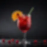 A vibrant red cocktail garnished with a slice of citrus and cherry