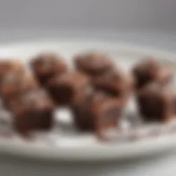 Delicious brownie bites displayed on a white plate with chocolate drizzle